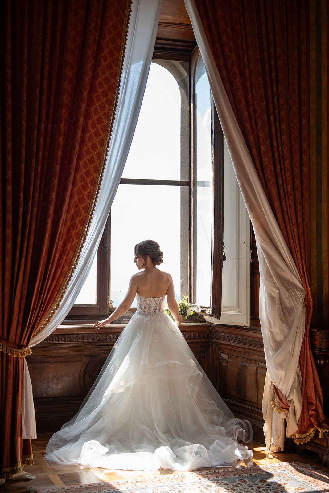 Bride by a sunlit villa window